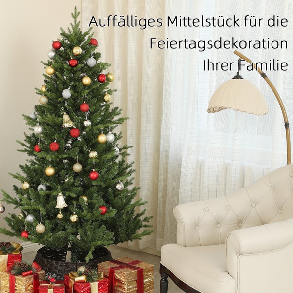 Geschmückter künstlicher Weihnachtsbaum mit roten, goldenen und silbernen Kugeln neben einem hellen Sessel und Geschenken.