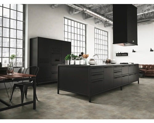 Moderne Küche im Industrial Style mit schwarzer Kücheninsel, Hochschränken und Dunstabzugshaube in einem hellen Loft mit Sichtbetondecke.