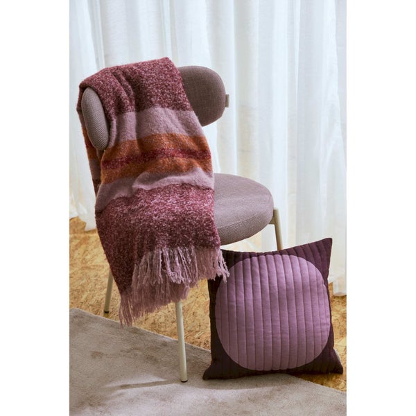 Dekorative Szene mit Stuhl, gestreifter Decke und Zierkissen