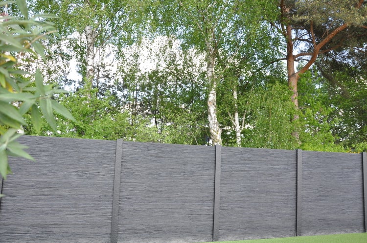 Grauer Sichtschutzzaun mit Baumstruktur im Garten