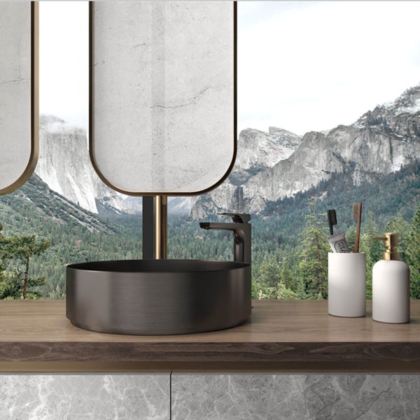 Modernes Badezimmer mit rundem Aufsatzwaschbecken, Armatur auf Holzwaschtisch, ovalen Spiegeln und Bergblick durch ein Fenster.