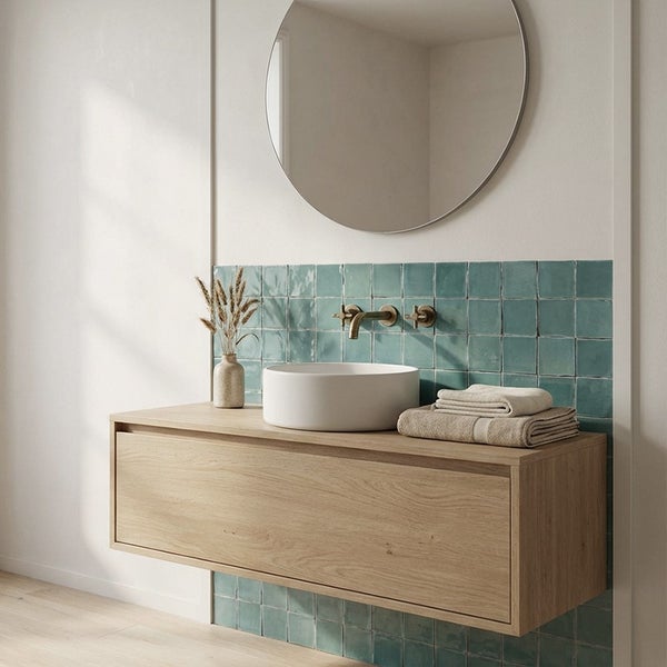 Modernes Badezimmer mit hängendem Waschtisch aus Holz, rundem Aufsatzwaschbecken, Wandarmatur, rundem Spiegel und grüner Fliesenrückwand.