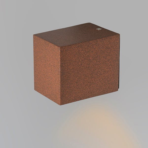 Würfelförmige Außenwandleuchte mit strukturierter rostfarbener Oberfläche und nach unten gerichtetem Lichtstrahl.