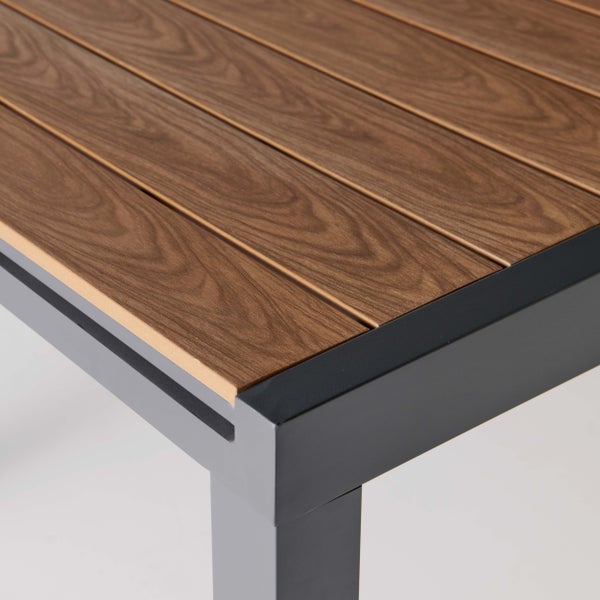 Detailansicht einer Gartentisch-Ecke mit dunkelgrauem Metallrahmen und Lamellen in Holzoptik.