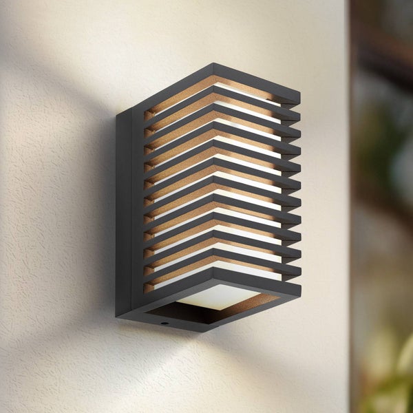 Moderne Außenwandleuchte in Kastenform mit dunklem Rahmen, horizontalen Lamellen und warmweißem Lichtaustritt.