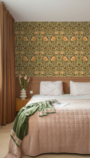 Schlafzimmer mit Bett, gemusterter Tapete und Vorhängen