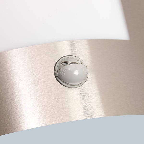 Nahaufnahme eines Bewegungsmelders an einer Leuchte aus gebürstetem Metall.