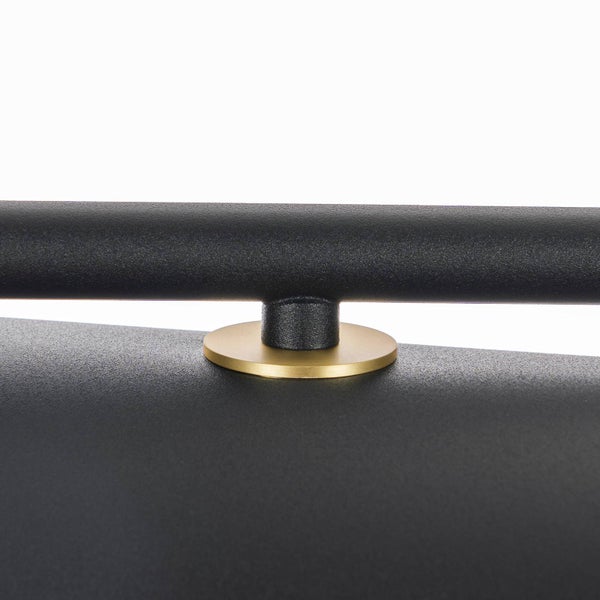 Detailansicht eines schwarzen Metallgrills mit goldener Applikation.