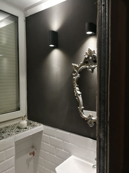 Badezimmer mit Waschbecken, Spiegel und Wandleuchten