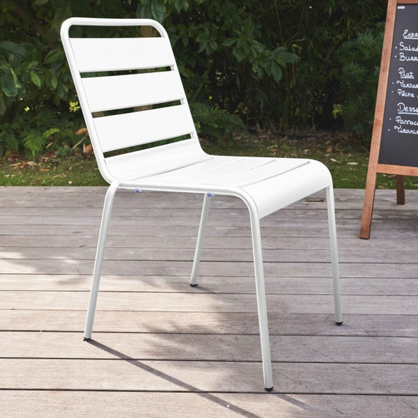 Weißer Gartenstuhl aus Metall mit Querstreben auf einer Holzterrasse im Garten.