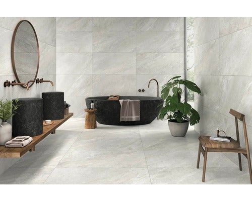 Helles Badezimmer mit Fliesen an Wänden und Boden, Badewanne und Waschtisch