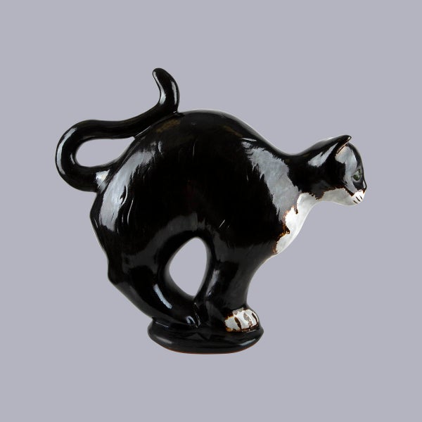 Dekorative schwarz-weiße Katzenfigur aus glänzender Keramik mit Katzenbuckel.