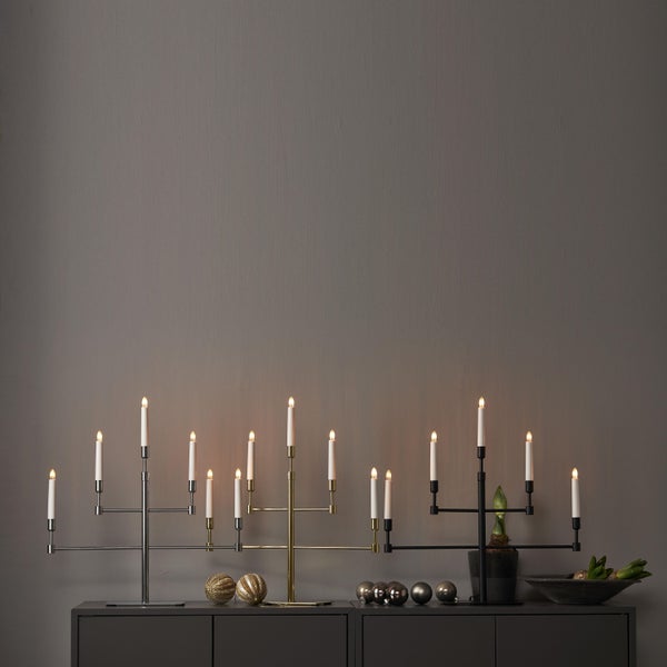 Dekoratives Arrangement mit Kerzenleuchtern, Weihnachtskugeln und Pflanzschale auf einer Kommode