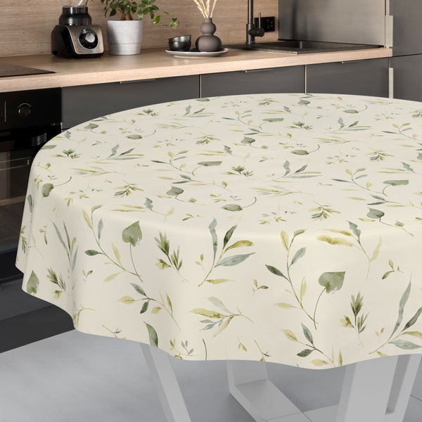 Runde Tischdecke mit botanischem Blättermuster auf einem Küchentisch in einer modernen, hellen Küche.