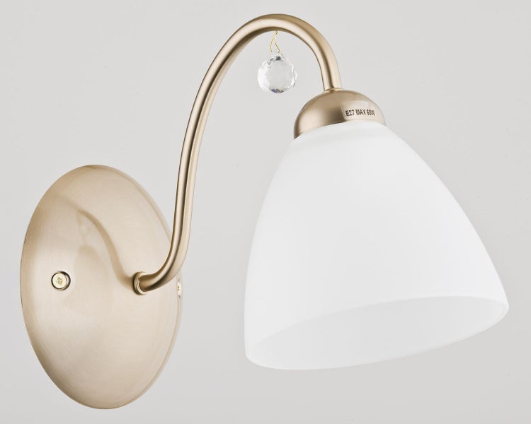 Klassische Wandleuchte mit geschwungenem Arm und milchigem Glasschirm sowie einem kleinen Kristallanhänger für E27 Leuchtmittel.