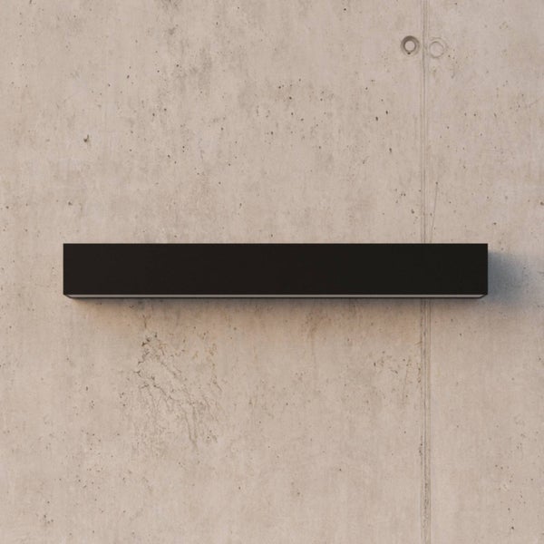 Moderne schwarze Wandleuchte in rechteckiger, länglicher Form.