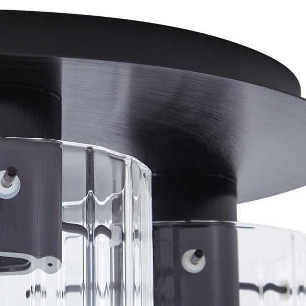 Nahaufnahme einer Deckenleuchte mit schwarzer gebürsteter Metallbasis und geriffelten Glasschirmen aus Klarglas.