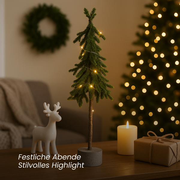 Dekoratives Arrangement mit einem künstlichen Tannenbaum, einer Figur eines Rentiers, einer Kerze und einem Geschenk