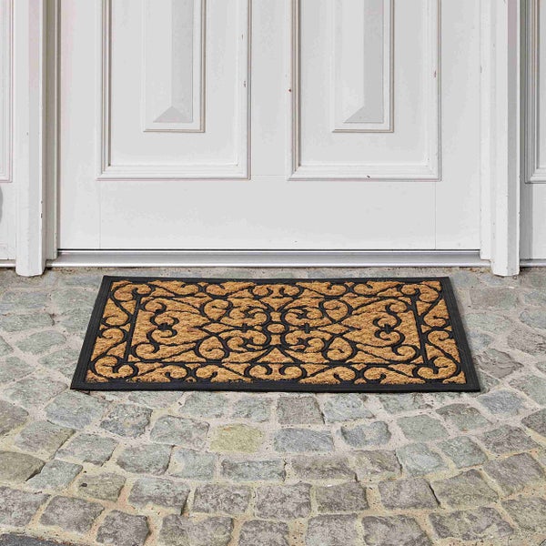 Fußmatte aus Kokosfaser mit Ornamentmuster vor einer Tür