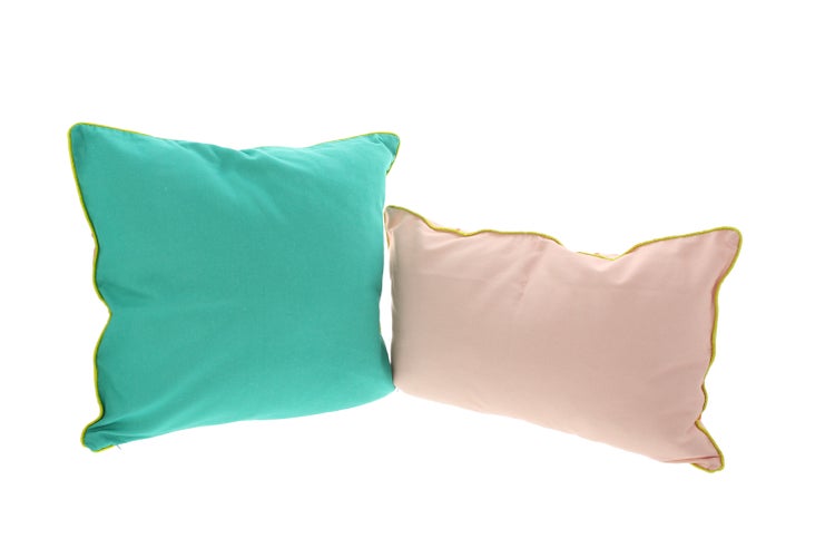 Zwei dekorative Kissen mit farblich abgesetzten Rändern