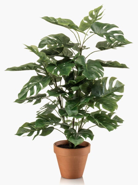 Künstliche Monstera-Pflanze in einem terrakottafarbenen Kunststofftopf.