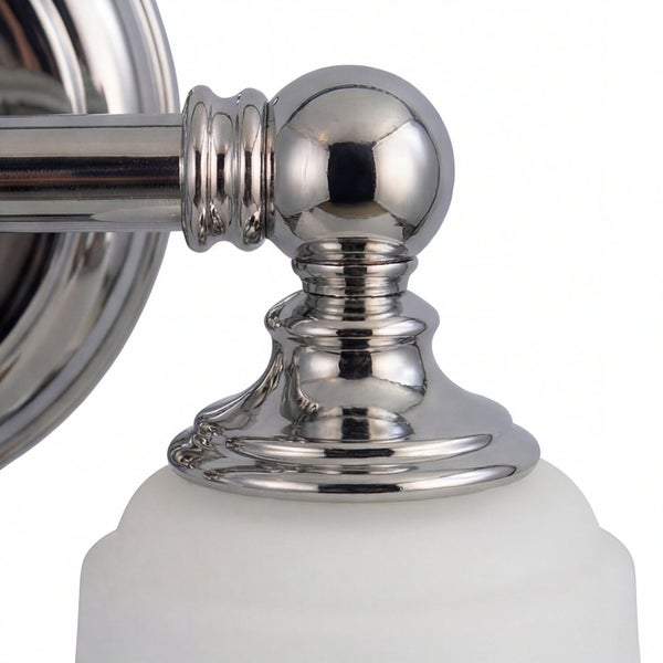 Detailaufnahme einer Wandleuchte mit Schirm aus Glas und Metallarm