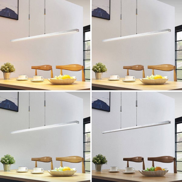 Moderne, lineare LED-Pendelleuchte aus silbernem Metall über einem Esstisch aus Holz in einem hellen Esszimmer.