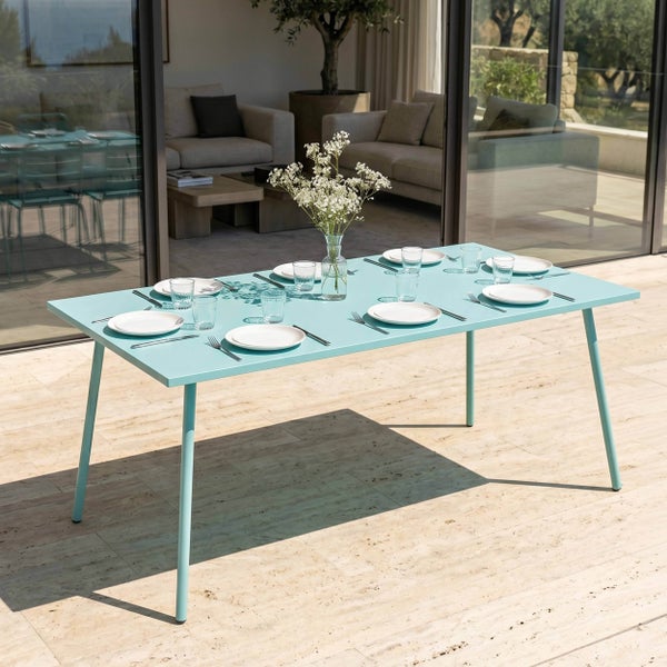 Hellblauer rechteckiger Gartentisch aus Metall für acht Personen auf einer Terrasse, eingedeckt mit Geschirr und einer Blumenvase.