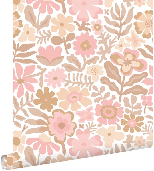 Vliestapete mit floralem Muster in Rosa und Beige in einem hellen Kinderzimmer über einer beigen Kommode.