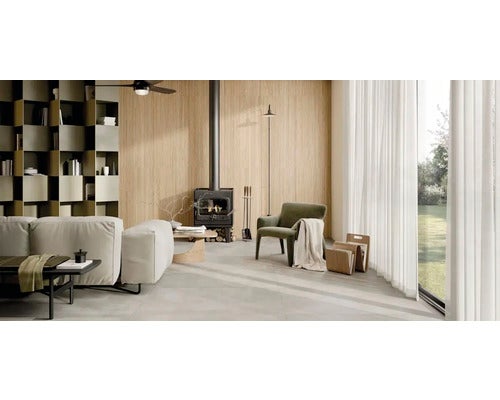 Helles Wohnzimmer mit Couch, Sessel, Bücherregal und Kamin