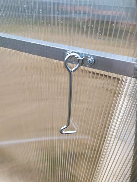 Detailansicht eines Hakenverschlusses an einer Gewächshaustür