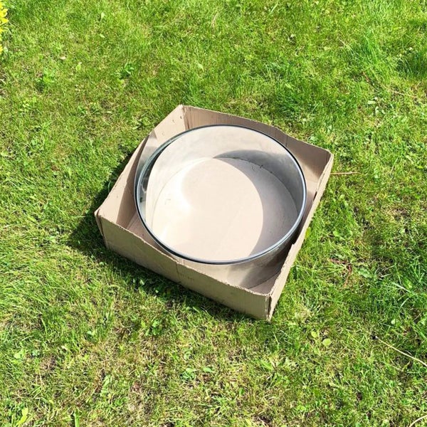 Runde Kuchenform in einem Karton auf einer Wiese