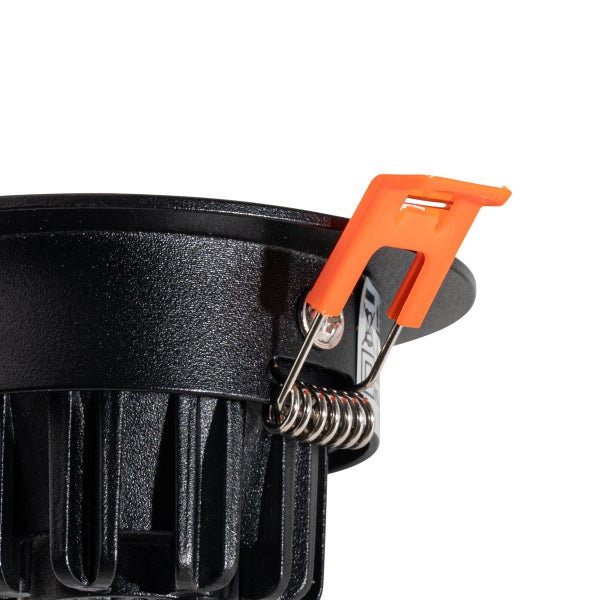Detailansicht eines schwarzen Einbaustrahlers mit orangefarbenem Montageclip und Metallfeder zur Deckenbefestigung.