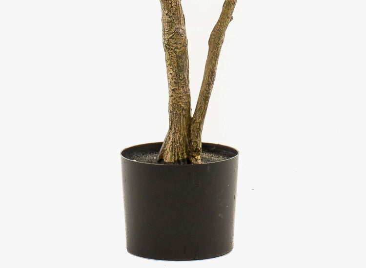 Künstlicher Baum mit grünen Blättern und zwei Stämmen in einem schwarzen Topf.