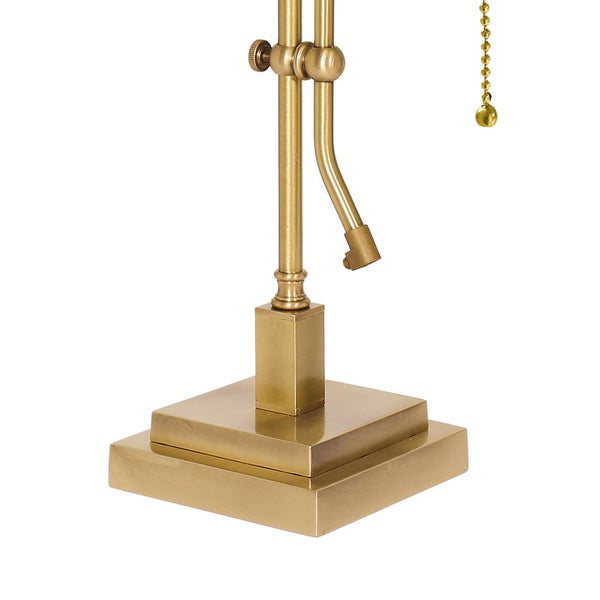 Detailaufnahme einer goldenen Tischleuchte mit verstellbarem Arm und Zugschalter