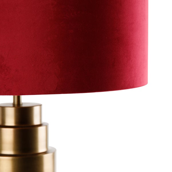 Detailansicht einer Tischleuchte mit rotem Schirm und mehrstufigem Metallsockel