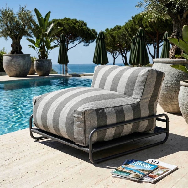 Gestreifter Outdoor Loungesessel auf einem Metallgestell neben einem Pool im Garten.