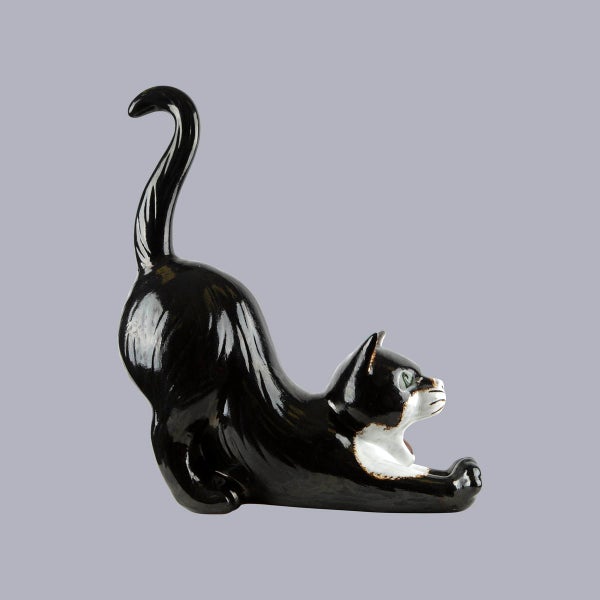 Dekofigur Katze aus Keramik, schwarz-weiß, sich streckend, glänzende Oberfläche.