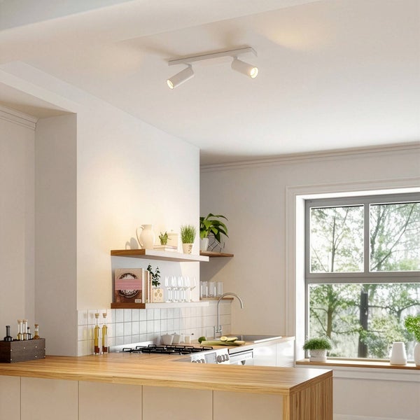 Zwei Deckenstrahler beleuchten eine helle Küche mit Holztheke