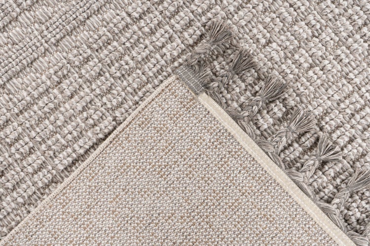 Strukturierter Teppich mit Fransen, Detailaufnahme der Oberfläche und Rückseite, gewebtes Textilmaterial.