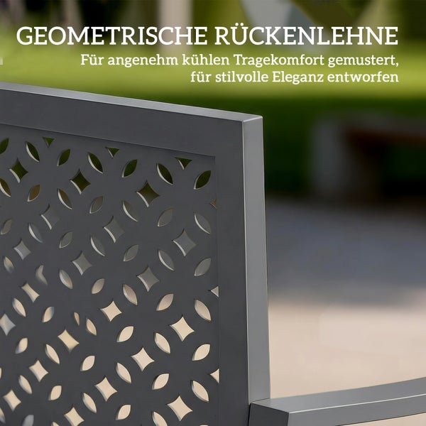 Graue Gartenbank aus Metall auf einer sonnigen Steinterrasse mit einer sitzenden Frau und einem stehenden Mann.