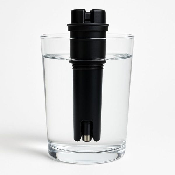 Schwarzer Wasserqualitätsmesser in einem Glas Wasser