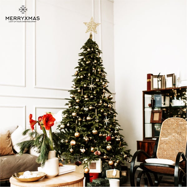 Weihnachtlich dekorierter Wohnraum mit Christbaum, Christbaumspitze in Sternform, Geschenken und Dekorationen.