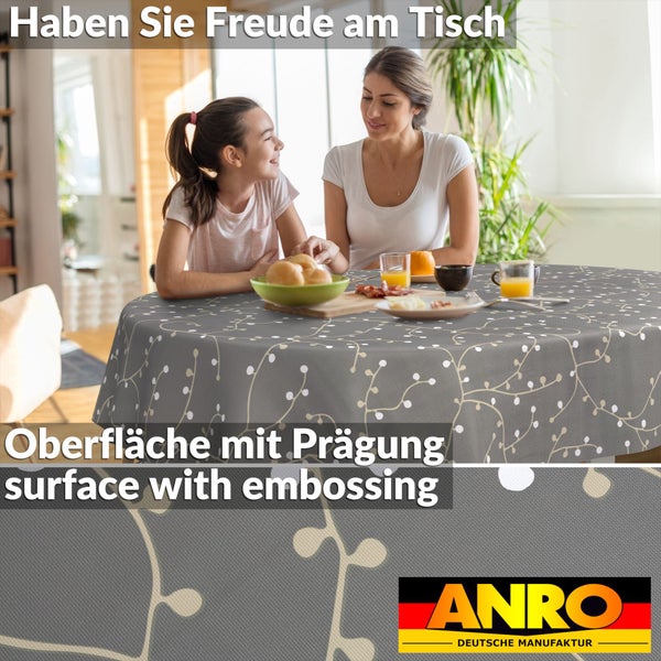 Runde Tischdecke mit geprägter Oberfläche und Zweigmuster, gedeckter Tisch mit Mutter und Kind in einem hellen Raum, ANRO Logo.