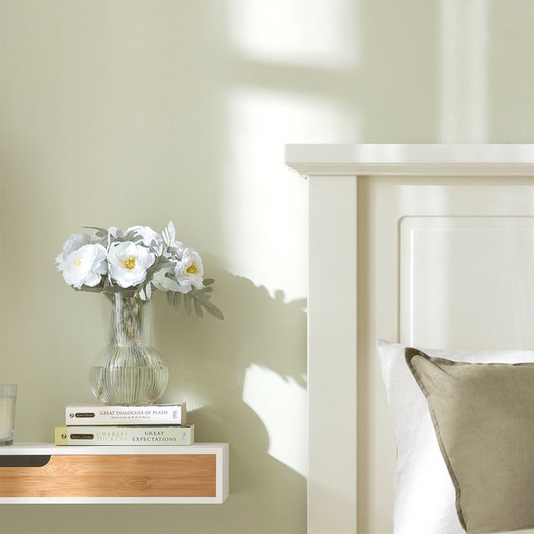 Schlafzimmer mit Nachttisch, Blumen in Vase und Bücher