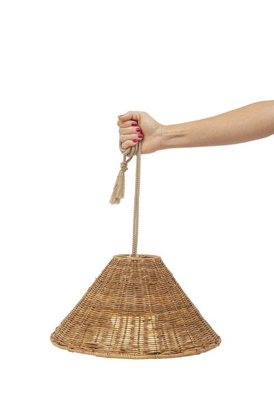 Eine Hand hält eine konische Pendelleuchte aus geflochtenem Rattan mit einem Textilkabel.