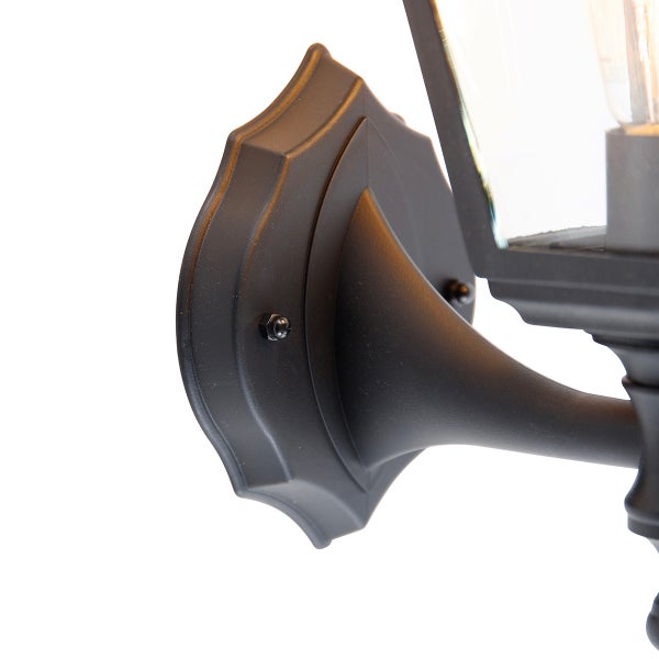 Detailansicht der Wandhalterung und des Arms einer schwarzen Außenwandleuchte im Laternen-Stil.