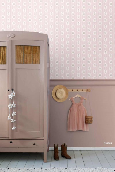 Kinderzimmer mit Mustertapete und Holzschrank. Die Tapete zeigt florale Kreise auf Streifen im oberen Teil und eine glatte Fläche im unteren Teil.