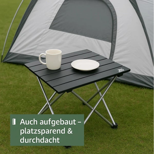 Quadratischer Campingtisch mit Tasse und Teller vor einem Zelt