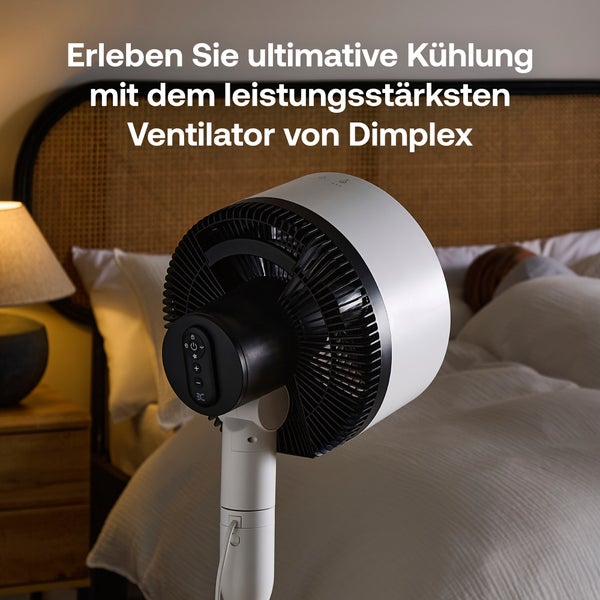 Moderner Standventilator von Dimplex in einem Schlafzimmer neben einem Bett mit weißer Bettwäsche und einer Nachttischlampe.